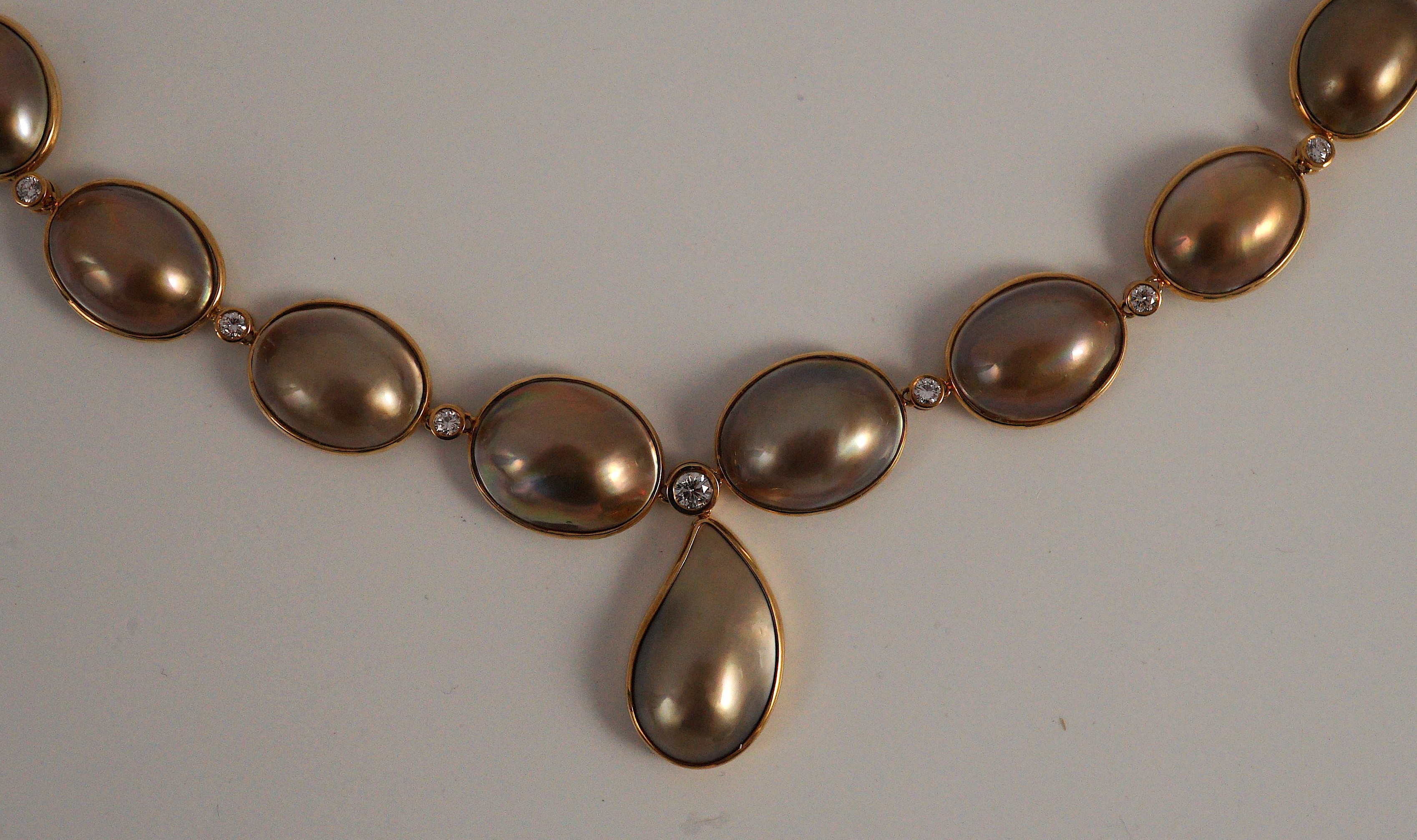 A cased modern single strand graduated shaped mabe pearl and round brilliant cut diamond set drop necklace, with 18ct gold clasp and chain section
